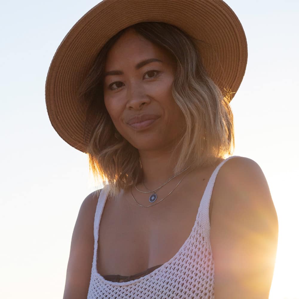 a woman wearing a hat and smiling at the camera