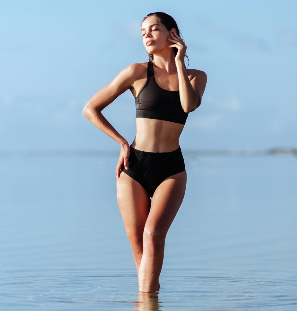 a woman standing next to a body of water